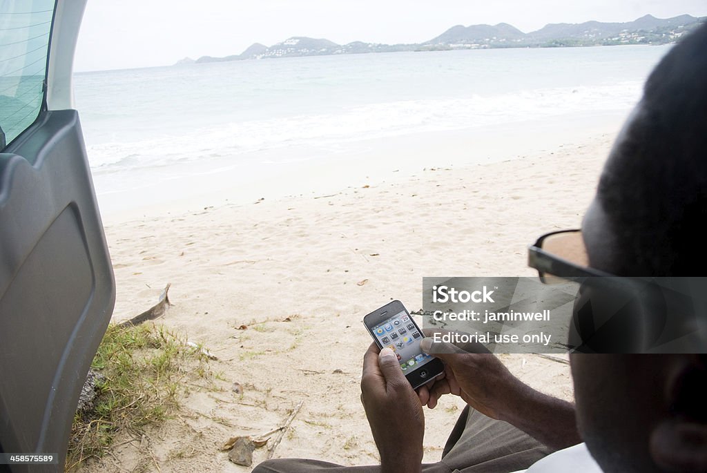 Mann auf apple iphone am Strand - Lizenzfrei Apple Computer Stock-Foto