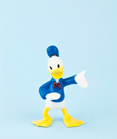 Suffolk, Virginia, USA - April 30, 2011: A vertical studio shot of the Disney cartoon character Donald Duck, who is dressed in a sailor outfit and is standing with his arm outstretched.