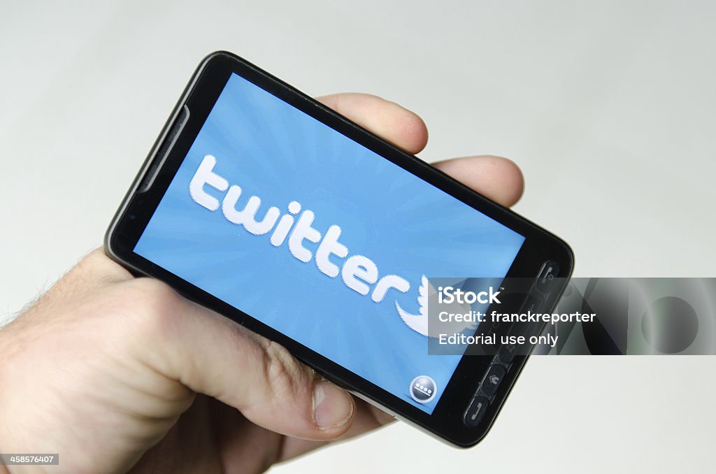 Mão segurando um smarthphone mostrando twitter aplicação - Foto de stock de Mensagens online royalty-free