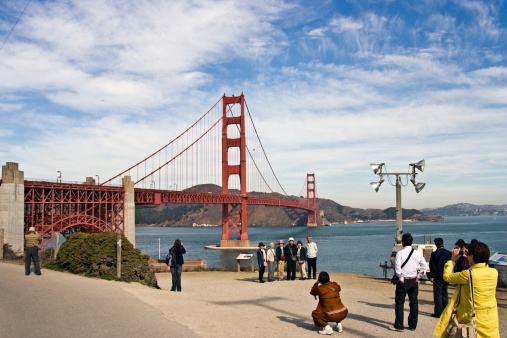 San Francisco, USA - October 17, 2008: Asian tourists posing for photographs with the Golden Gate Bridge in the background.