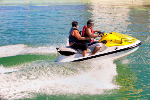 Cozemel, Mexico - Janurary,  31st  2011: Hispanic tourists catching air on a rented jet ski
