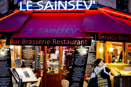 Paris, France - December 28, 2012: Le Sainsev Bar Brasserie Restaurant Entrance, Paris. Menu displayed outdoors, window display is decorated for Christmas and New Year celebration.