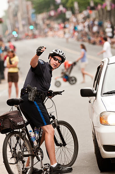 Everett, United States - August 30, 2016: This image shows 2 motorcycle police officers on duty outside the Trump Rally in downtown Everett, Washington. Police officers have the area surrounding the venue blocked off from traffic. There are supporters of Donald Trump lined up from the Trump Rally location all along the city streets.