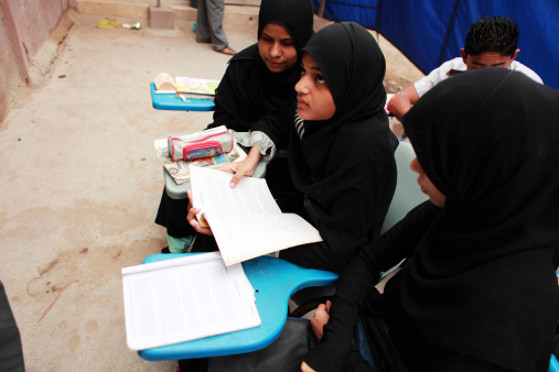 Karchi, Pakistan - July 12, 2010: Muslim girls in traditional attire attends class in Street School run by ARM child and youth welfare in Lyari. All classes run side by side in one of the congested lanes of Lyari one of the oldest slum in town.