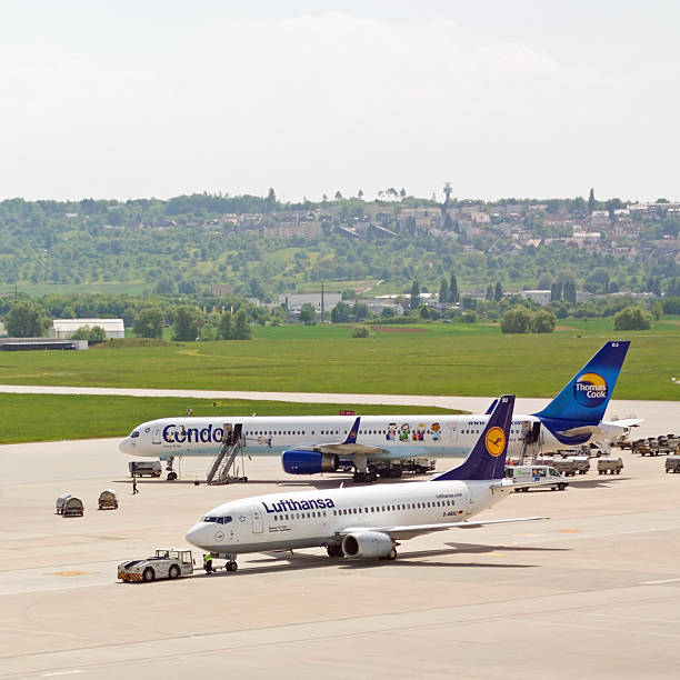 Lufthansa and Condor at Stuttgart Airport Stuttgart, Germany - May 6, 2011: Photo of a Lufthansa and a Condor/Thomas Cook jet at Stuttgart International Airport (EDDS). The Lufthansa Boeing 737 is pulled to the runway, while the Condor Boeing 757 gets prepared for boarding. boeing 757 stock pictures, royalty-free photos & images