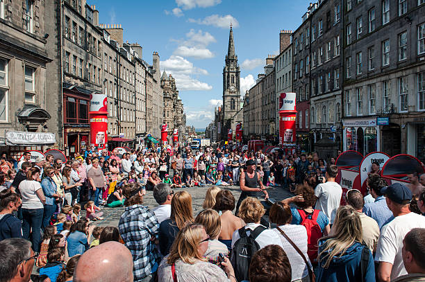 Edinburgh, United Kingdom - July 30, 2013: People following a street performer on the Royal Mile, Edinburgh, Scotland, a few days before the official start of the Fringe Festival (2-26 August), the most famous festival of the street arts of the World.