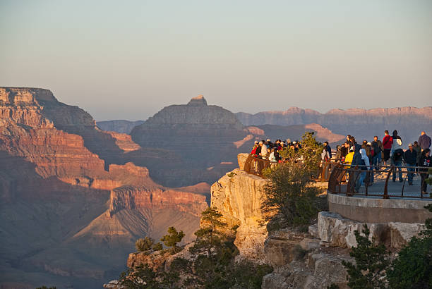 Crowds of Tourists Watch the Sunset from Mather Point Grand Canyon National Park, Arizona, USA - May 15, 2011: Tourists are watching the sun set over the Grand Canyon from Mather Point. jeff goulden grand canyon national park stock pictures, royalty-free photos & images