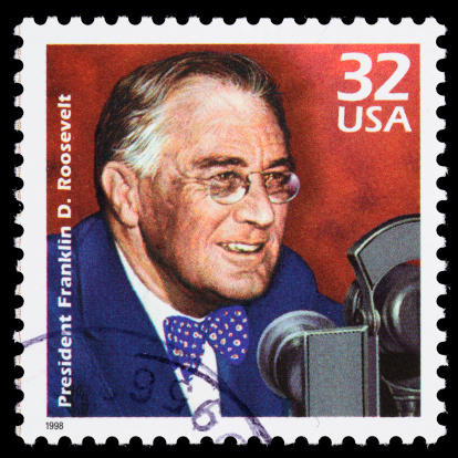 Sacramento, California, USA - March 20, 2011: A 1998 USA postage stamp with an illustration of Franklin Delano  Roosevelt (1882-1945) speaking into radio microphones. Often referred to as FDR, his series of radio addresses during the Great Depression became known as &amp;amp;amp;quot;fireside chats&amp;amp;amp;quot;. Stamp design by Paul Calle.