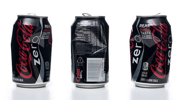 bumped coca-cola zero can views Miami, USA - July 3, 2011: Bumped coca-cola zero can. Coca-Cola Zero or Coke Zero is a product of the Coca-Cola Company. It is a low-calorie (0.75 calories per bottle) variation of Coca-Cola specifically marketed to males, who were shown to associate \'diet\' drinks with women. The Coca-Cola Zero logo has generally featured the script Coca-Cola logo in red with white trim on a black background, with the word \"zero\" underneath in lower case in the geometric typeface Avenir (or a customised version of it). Some details have varied from country to country. The British logo, for example, originally had the \"o\" taking a spiral form. In the U.S., the letters decline in weight over the course of the word. coke zero photos stock pictures, royalty-free photos & images