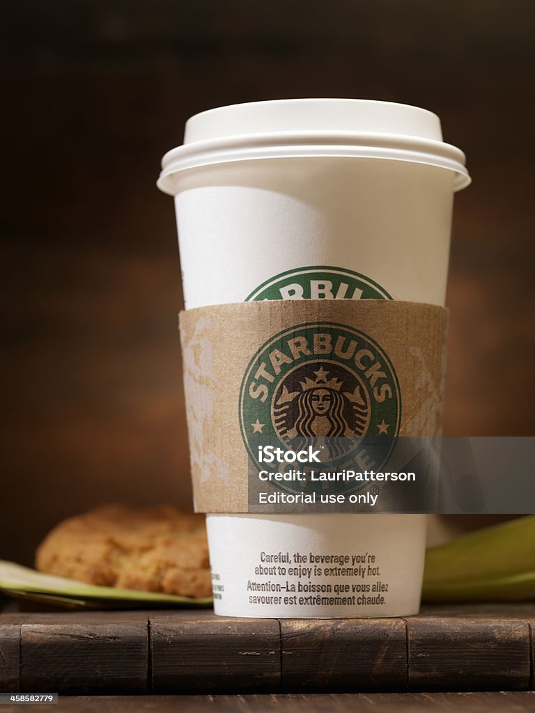 Starbucks &quot;Grande&quot; 16oz Coffee with a Peanut Butter Cookie Calgary, Canada - February 8, 2011 : A Starbucks "Grande" 16oz Coffee with a Peanut Butter Cookie. Shot in a photography studio on a wood table. Starbucks Stock Photo