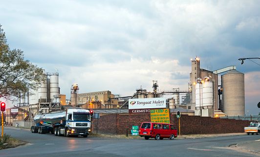 Germiston, South Africa - April, 21st 2012: Tongaat Hullet Sugar Mill in Germiston at sunset under heavy clouds. Tongaat Hullet is a large Corporate Company focussed in the sugar industry in South Africa.
