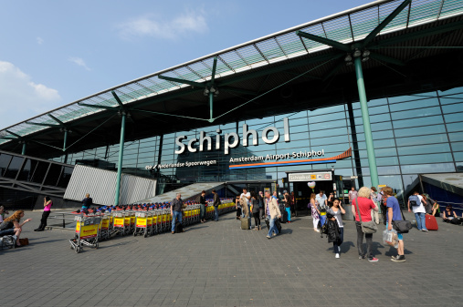 Haarlemmermeer, the Netherlands - April 22, 2011: Group of travellers at the entrance of Amsterdam Airport Schiphol and Schiphol railway station. Schiphol is located 9 kilometers southwest of Amsterdam.