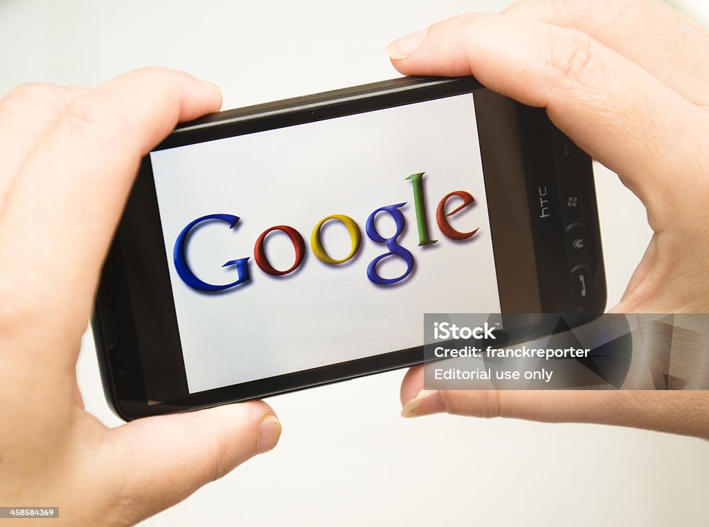 Mano sosteniendo teléfono inteligente con Google logotipo - Foto de stock de Google - Marca comercial libre de derechos