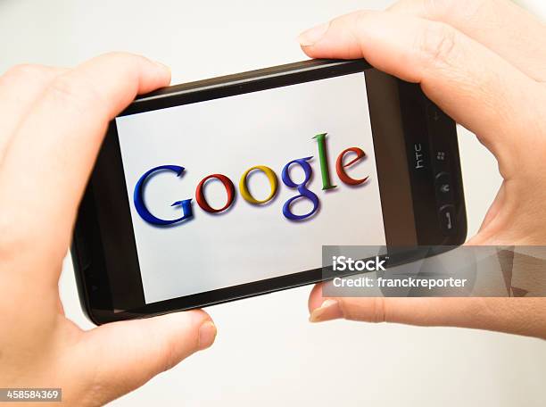 Mano Sosteniendo Teléfono Inteligente Con Google Logotipo Foto de stock y más banco de imágenes de Google - Marca comercial