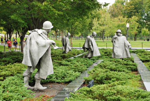Washington, DC, USA - October 10, 2009: Four statues of soldiers comprising part of the Korean War Veterans Memorial are seen as tourists and sightseerss approach in the background. The memorial is located in Washington D.C.'s West Potomac Park.