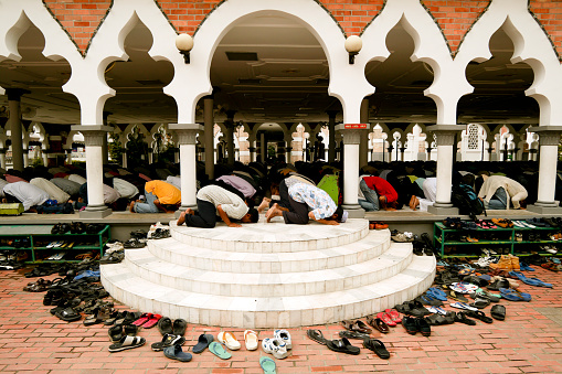 Kuala Lumpur, Malaysia - February 01, 2008: Muslim men praying at Masjid Jamek Mosque in downtown Kuala Lumpur, Malaysia. Masjid Jamek is the oldest mosque in Kuala Lumpur.