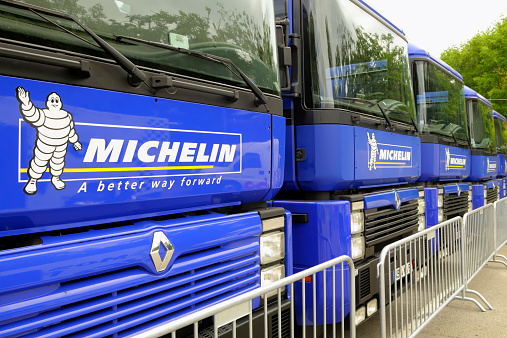 Spa, Beglium - July 31, 2010: Row of blue Michelin Renault trucks behind a fence. The Michelin symbol Bibendum is placed next to the brand name and slogan.