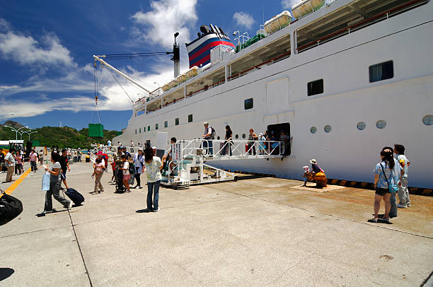 Futami port, Chichijima, Japan - August 3, 2007: Tourists disembarking the Ogasawara Maru in Chichijima (Futami Harbor) on a beautiful summer day. After having completed a 25.5 hours and 1000 km long ferry ride they are rewarded with beautiful, unspoiled seascape. Taking the relaxing, weekly ferry ride is the only way to reach the paradise island of Chichijima, Ogasawara, Japan, which has been declared as a UNESCO world heritage site in 2011.