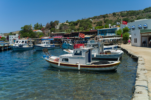 mugla, turkey - June 9, 2012: fishing boats are waiting in front of traditional fish restaurants at gumusluk bay of bodrum turkey