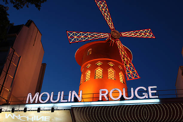 Le Moulin Rouge at the dusk Paris, France - July 31, 2011: Le Moulin Rouge(Red Mill) is a cabaret built in 1889. It\'s situated near Montmartre in the district of Pigalle in the 18th arrondissement of Paris. On this picture le moulin rouge is at the dusk.  place pigalle stock pictures, royalty-free photos & images