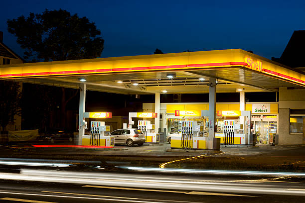 la station essence shell de nuit - gas station service red yellow photos et images de collection
