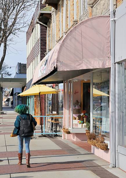 Royal Oak, Michigan, USA - April 21, 2011: A person with green hair walks down the sidewalk in downtown Royal Oak. Royal Oak, Michigan is a college town and suburb of Detroit. The downtown area offers a variety eclectic shops and restaurants.
