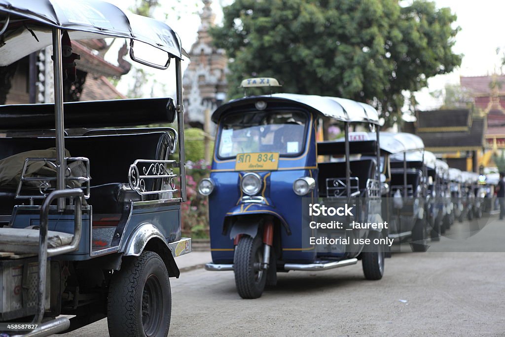 Tuk-tuk in Thailand Chiang Mai, Thailand - March 31, 2011: tuk-tuk parked in single file in a square in Chiang Mai, Thailand. Traditional rickshaws, waiting on the road for customers. Asia Stock Photo