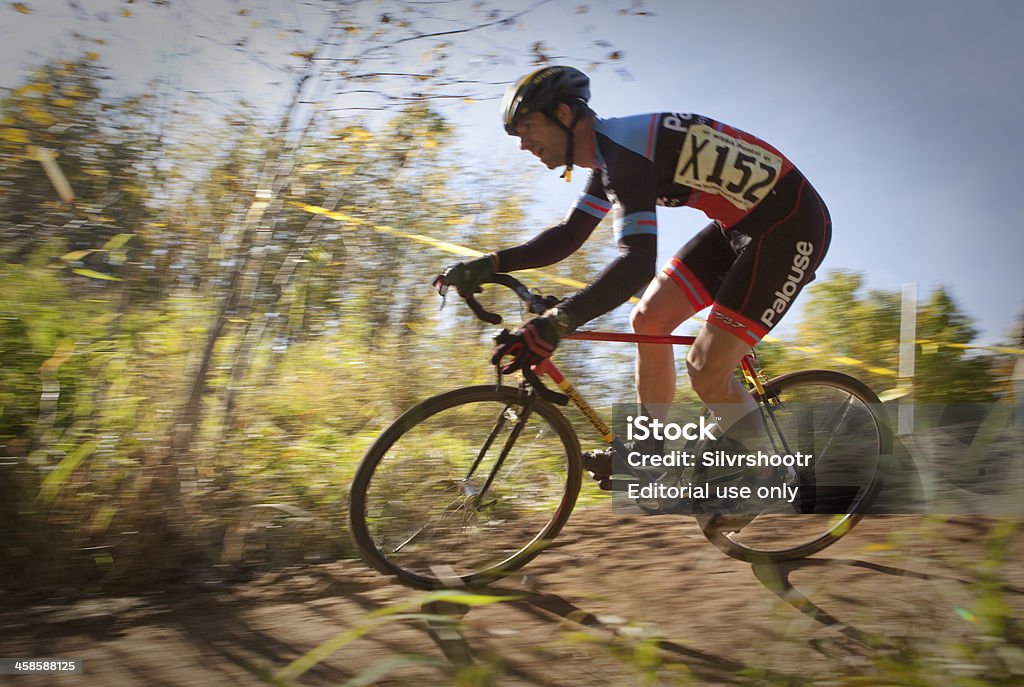 Cyclocross racer entering a corner Sandpoint, ID, USA - October 6, 2013: Racers become a blur of motion as they negotiate a turn during a race in northern Idaho. Cyclocross uses bicycles similar to road bikes to race around a dirt course filled with obstacles that racers must conquer. Cyclo-Cross Stock Photo