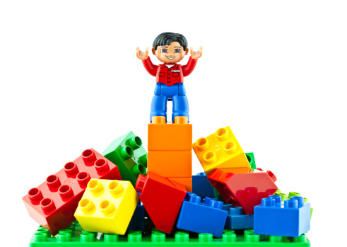 Suffolk, Virginia, USA - April 12, 2011: A horizontal studio shot of Lego brand Duplo bricks scattered around a Duplo man who is standing on top of them with his arms outstretched.