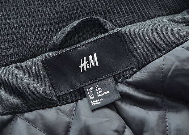H&M Label Vancouver, Canada -- November 16, 2011:Close up of a coat with the H&M label and logo.  H&M is a Swedish based clothing retailer that has stores all over the world. h and m stock pictures, royalty-free photos & images