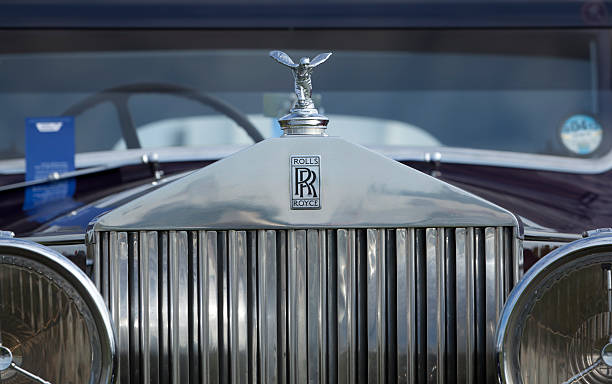 Rolls-Royce Chichester, West Sussex, England - September 16, 2011: The Spirit of Ecstacy (also known as "Emily", "Silver Lady", "Flying Lady") hood ornament on a vintage Rolls-Royce car. It has the form of a woman bending forwards with her arms outstretched behind her. Billowing cloth resembling wings runs down her arms to her back. This is the kneeling version, from 1934. rolls royce stock pictures, royalty-free photos & images