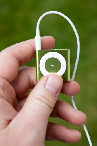 Portland, Oregon, USA - May 24, 2011: Apple iPod Shuffle, 4th Generation, is the very small portable mp3 player that will play your music, podcasts or audio books with the new VoiceOver function to help with navigation between songs and playlists.