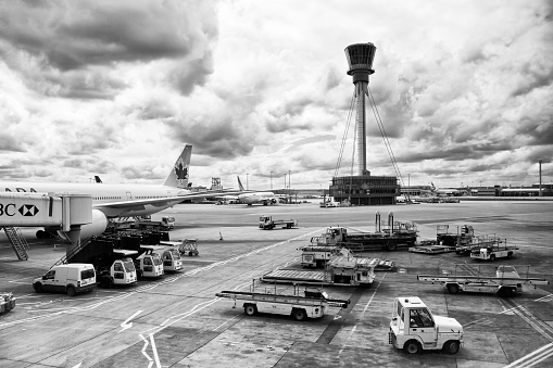 London, United Kingdom - May 8, 2011: Control Tower at Heathrow Airport in, London, United Kingdom. This shot shows an Air canada flight being readied for take-off as well as many other planes and airport vehicles that are used throughout the airport. heathrow Airport is the one of the busiest airports in European Union.