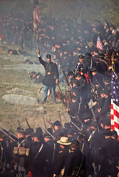 Civil War US Infantry Battlefield in Virginia Officer Leads Advance Middletown, USA - October 17, 1992: Civil War reenactors play the parts of Union infantry on the Cedar Creek Battlefield at the northern end of the Shenandoah Valley of Virginia. Northern troops, lead by an officer, prepare to attack. This is during a reenactment of the October 19, 1864 Battle of Cedar Creek which ended in a Union victory and eliminated significant Confederate presence in the valley. battle reenactment stock pictures, royalty-free photos & images