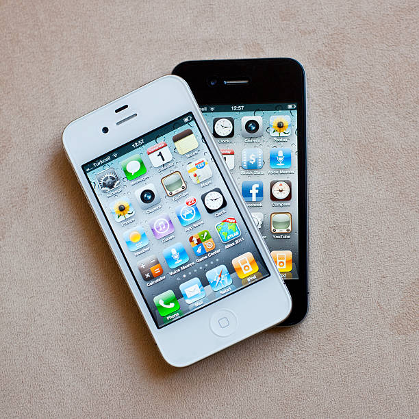 Antalya, Turkey - October 1, 2011: Black And White Versions Of iPhone4 on a plain background. Both are showing their home screens. iPhone is produced by Apple Inc.