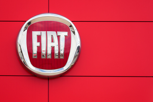 Saint John, New Brunswick, Canada - April 29, 2012: Fiat Logo and sign on a wall at a car dealership.  Reflection of dealership slightly visible in Fiat sign.  Fiat recently returned to the North American market with the popular Fiat 500 after a 27 year absence.