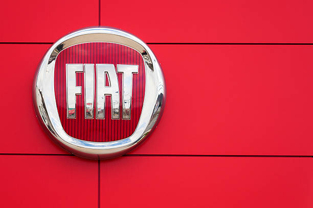 Fiat Logo and Sign Saint John, New Brunswick, Canada - April 29, 2012: Fiat Logo and sign on a wall at a car dealership.  Reflection of dealership slightly visible in Fiat sign.  Fiat recently returned to the North American market with the popular Fiat 500 after a 27 year absence. new brunswick canada photos stock pictures, royalty-free photos & images