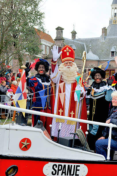 Sinterklaas arriving on his Steamboat with  black helpers Leidschendam, Holland - November 13, 2010: Ship decorated as Stoomboot (Steamboat) is arriving at the town of Leidschendam for the Dutch children's Sinterklaas holiday. Sinterklaas is standing and waving on deck and the Zwarte Pieten are dancing on the ship.November 13,2010 Leidschendam,Holland zwarte piet stock pictures, royalty-free photos & images