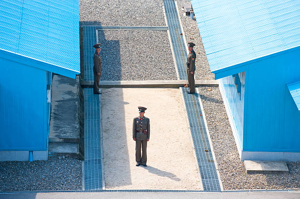 северокорейский солдат, стоя между синий зданий - panmunjom стоковые фото и изображения