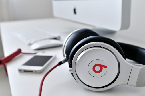 Budapest, Hungary - September 3, 2011: Beats by Dr. Dre Pro over ear headphones by Monster, white iPhone version 4, Apple iMac, Apple keyboard and Magic Mouse on a white table.