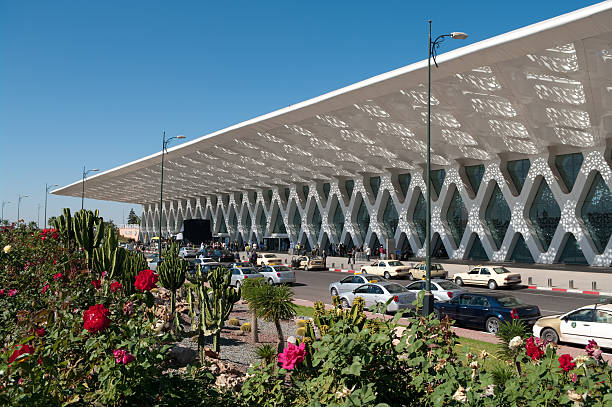 Marrakesh, Morocco, 10th November 2009:Afternoon scene outside the new Menara Marrakesh airport. Grand Taxis (beige cars) await passengers. Tourists and locals can be seen in background. In the extreme background a film crew can be seen filming on location. The airport is separated from the main carpark (off camera to left) by an attractive garden.