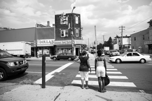 Philadelphia, Pennsylvania, USA - August 14, 2008: Two African American women waiting to cross an intersection in West Philadelphia, Pennsylvania.