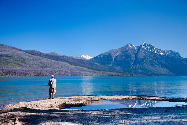 wędkowanie na jeziorze mcdonald - fisherman mcdonald lake us glacier national park lake zdjęcia i obrazy z banku zdjęć