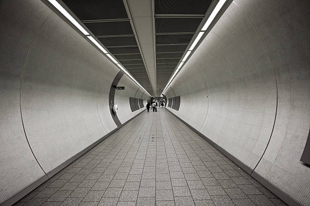 menschen in der u-bahn-station-tunnel in london - london england vanishing point underground diminishing perspective stock-fotos und bilder