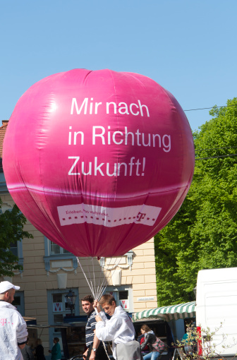 Potsdam, Germany - April, 30 2011: An advertising campaign for new technologies in the future. The German enterprise Telekom promotes the new broadband internet in the City of Potsdam. An advertising agent holds a pink balloon.