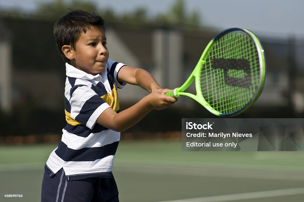 intense young tennis player Atlanta, USA - September 2008: A young boy learning to play tennis hustles and swings at the ball. Prince branded tennis racket. Child Stock Photo