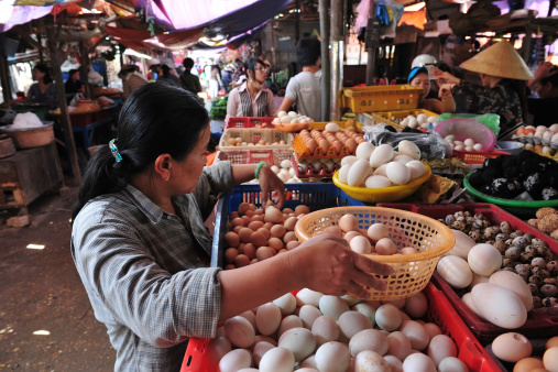 Hoi An, Vietnam - April 30, 2010: Vietnamese woman sells an eggs in crowded market at Hoi An, Vietnam.