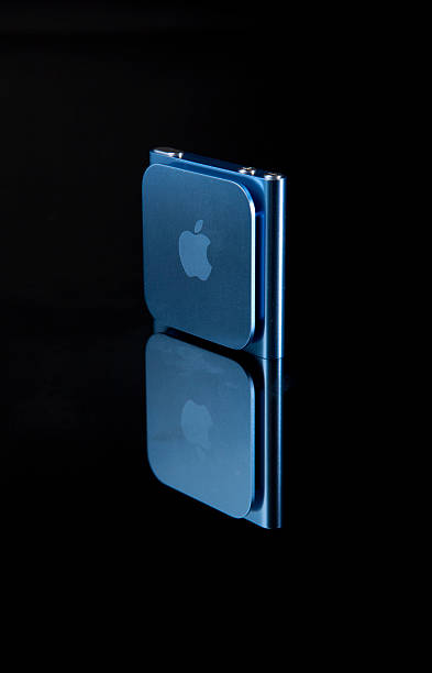 6th Generation Apple iPod Nano Portland, Oregon, USA - October 10, 2011: 6th Generation Apple iPod Nano with Multi-Touch technology. Photographed on reflective glass, showing the back of the unit in blue. ipod nano stock pictures, royalty-free photos & images