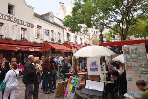 Paris, France, october 09, 2009: Painters work at Tertre square in Montmartre. This picturesque square is full of streetside paintings and crowded with tourists.