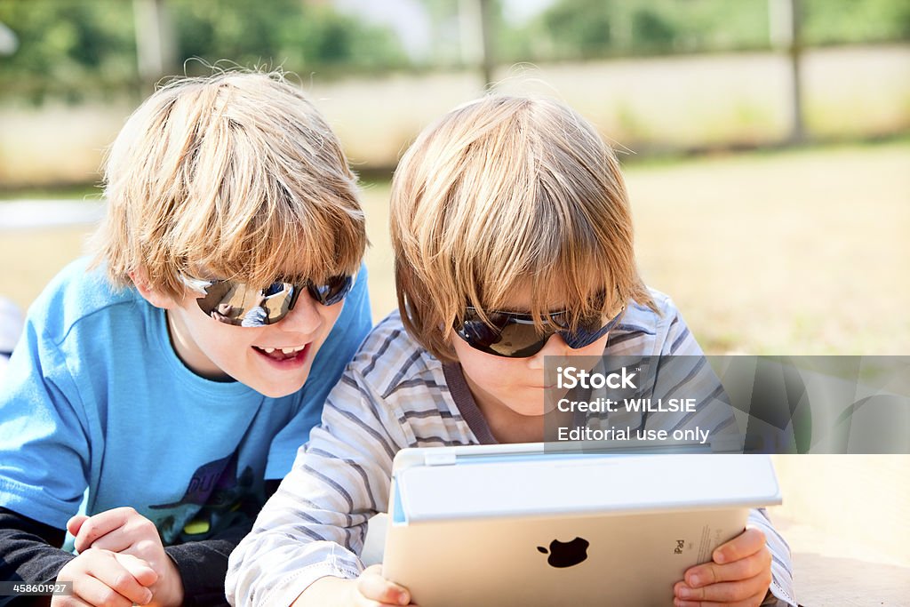 Duas crianças usando um iPad ao ar livre - Foto de stock de Agenda Eletrônica royalty-free